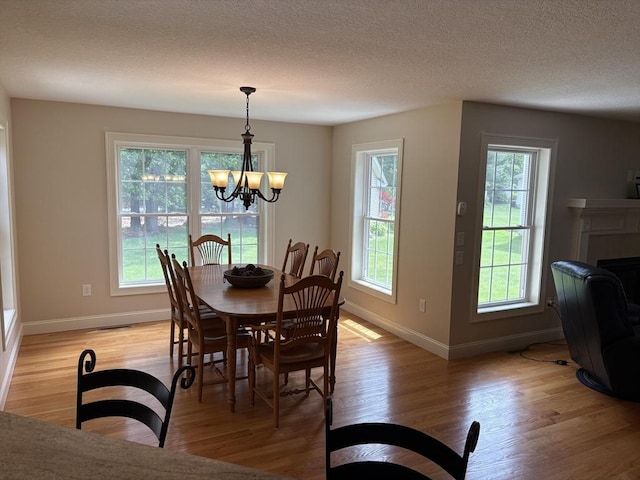 43 Caddyshack Dr, Chicopee, MA 01020 - dining room with plenty of natural light, light wood finished floors, a chandelier, and a textured ceiling