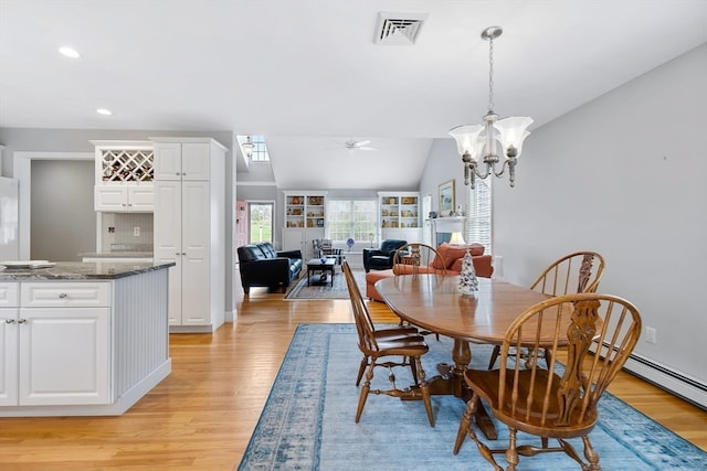 dining room featuring light hardwood / wood-style floors, ceiling fan with notable chandelier, and lofted ceiling