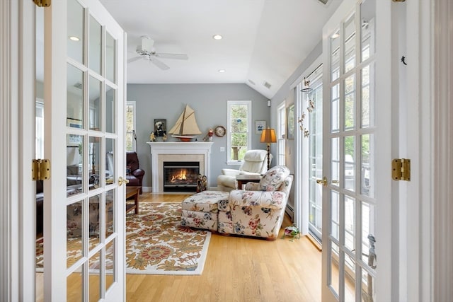 sitting room featuring vaulted ceiling, light wood-type flooring, ceiling fan, and french doors