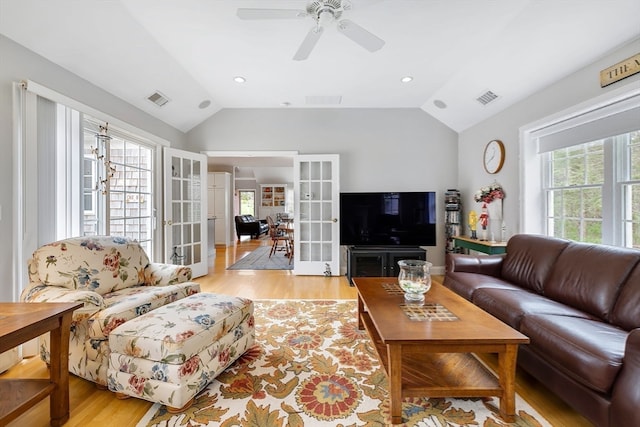 living room featuring french doors, ceiling fan, vaulted ceiling, and light hardwood / wood-style flooring