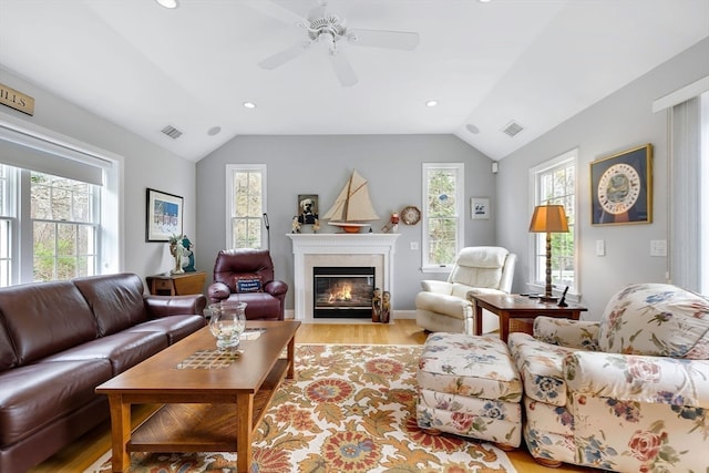 living room featuring a wealth of natural light, lofted ceiling, light wood-type flooring, and ceiling fan