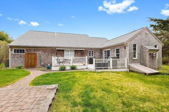 rear view of property with a deck and a lawn