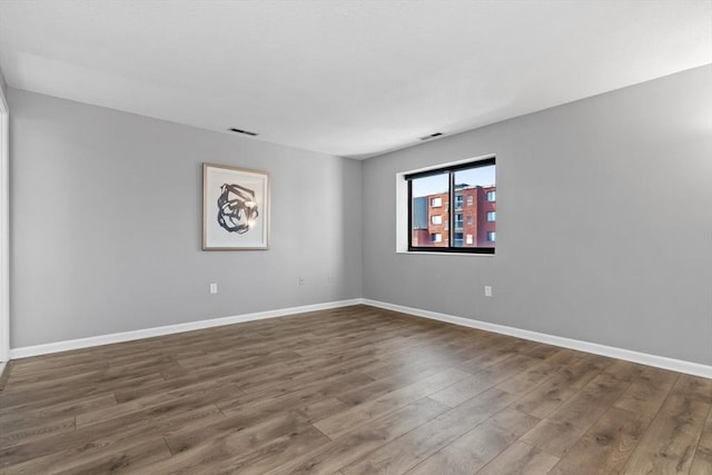 empty room featuring baseboards and wood finished floors