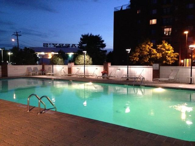pool at night with a community pool and fence