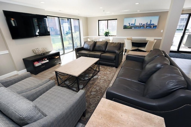 living area featuring baseboards, ornamental molding, and recessed lighting