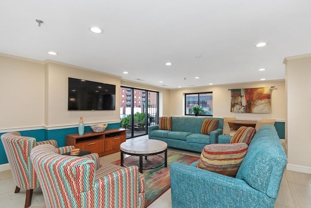 living room featuring baseboards, ornamental molding, and recessed lighting