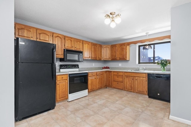 kitchen with brown cabinetry, a sink, black appliances, and light countertops