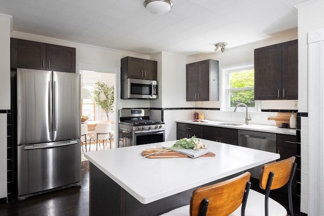 36 Warwick St, Somerville, MA 02145 - kitchen featuring stainless steel appliances, a sink, dark brown cabinetry, a breakfast bar, and light countertops
