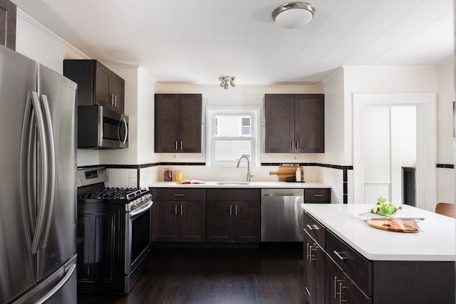 36 Warwick St, Somerville, MA 02145 - kitchen featuring stainless steel appliances, a sink, light countertops, dark wood finished floors, and dark brown cabinetry
