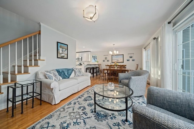 living room featuring hardwood / wood-style floors, crown molding, and a wealth of natural light