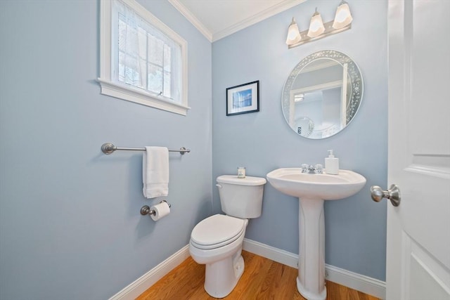 bathroom featuring hardwood / wood-style flooring, ornamental molding, toilet, and sink