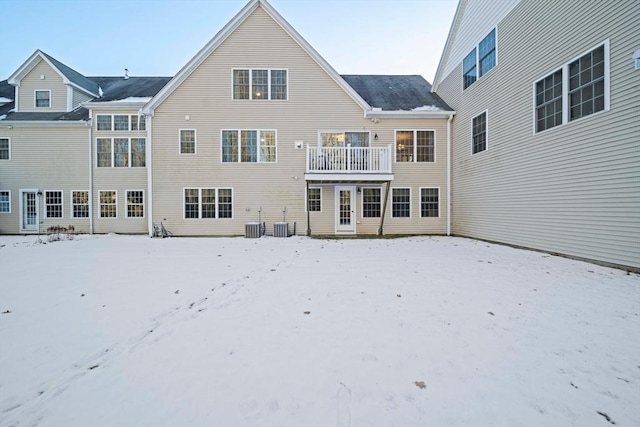 snow covered rear of property with central AC