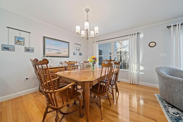 dining space featuring crown molding, a notable chandelier, and light wood-type flooring