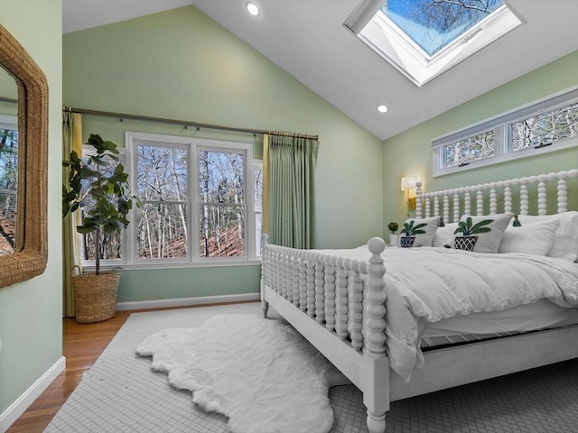 bedroom with baseboards, recessed lighting, wood finished floors, and a skylight