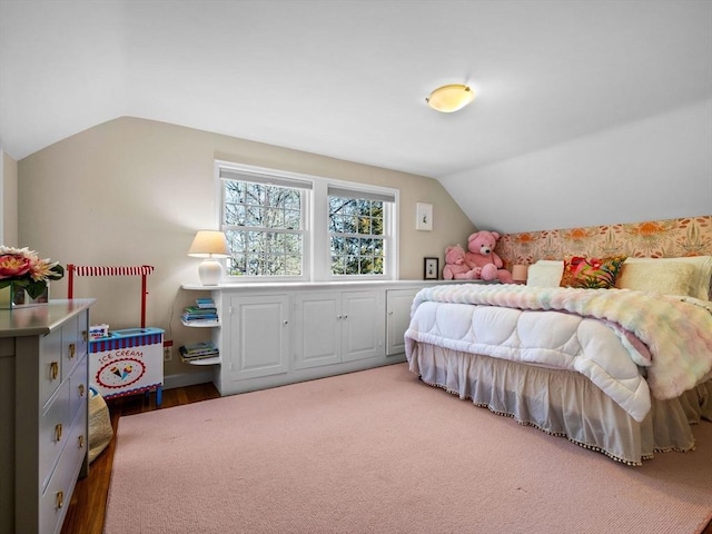 bedroom with wood finished floors and lofted ceiling