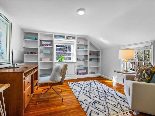 office with wood finished floors, baseboards, built in shelves, and lofted ceiling