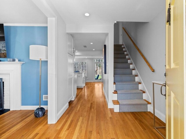 entrance foyer featuring stairway, light wood-style floors, baseboards, and visible vents