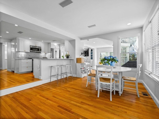 dining area featuring a wealth of natural light, recessed lighting, and light wood-style floors