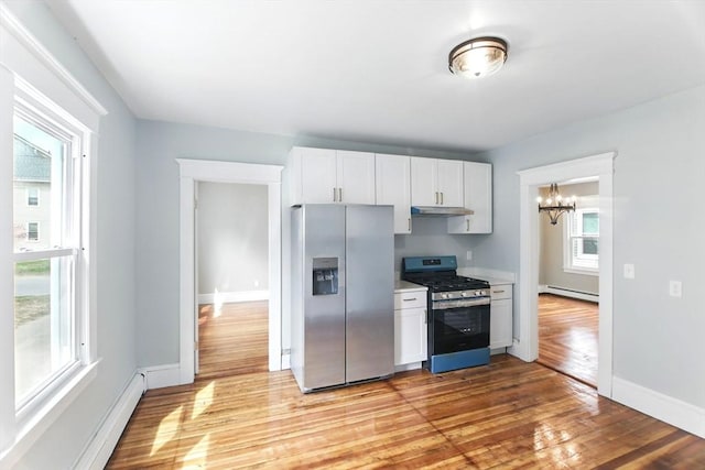 kitchen with an inviting chandelier, light wood-style floors, baseboard heating, a baseboard heating unit, and appliances with stainless steel finishes