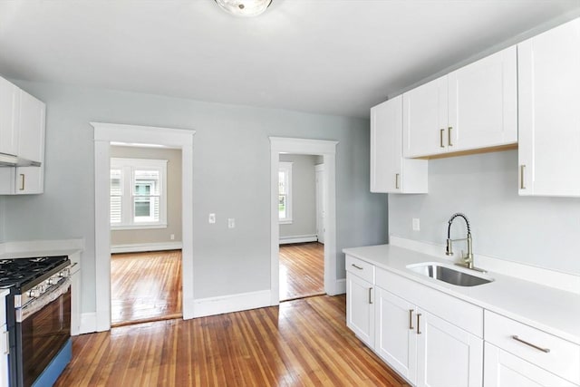kitchen featuring a sink, light countertops, plenty of natural light, and stainless steel gas range