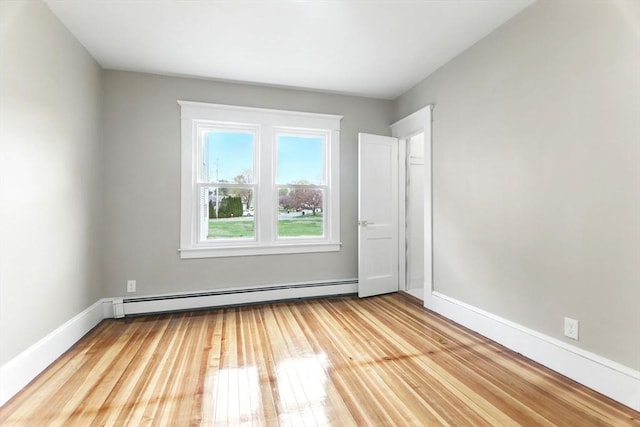 empty room with light wood-style floors, baseboards, and baseboard heating
