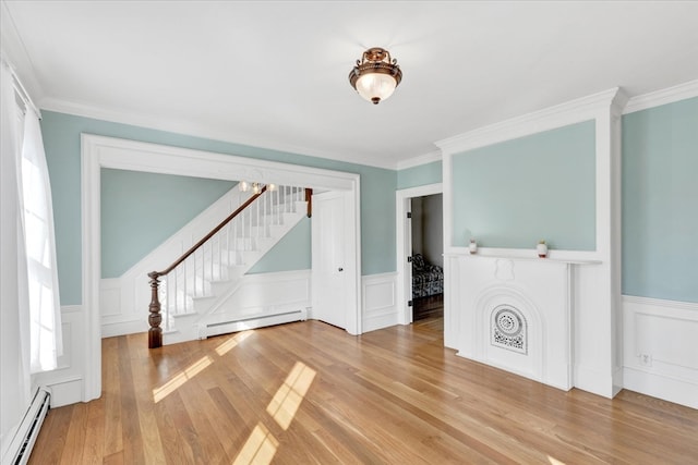 unfurnished living room with a baseboard radiator, hardwood / wood-style floors, and crown molding