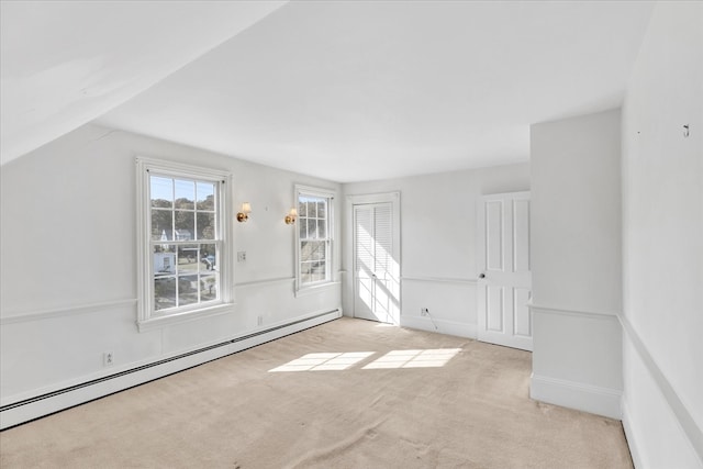 additional living space with lofted ceiling, a baseboard radiator, and light colored carpet