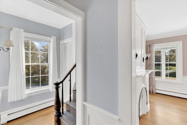 stairs with hardwood / wood-style floors and a baseboard radiator