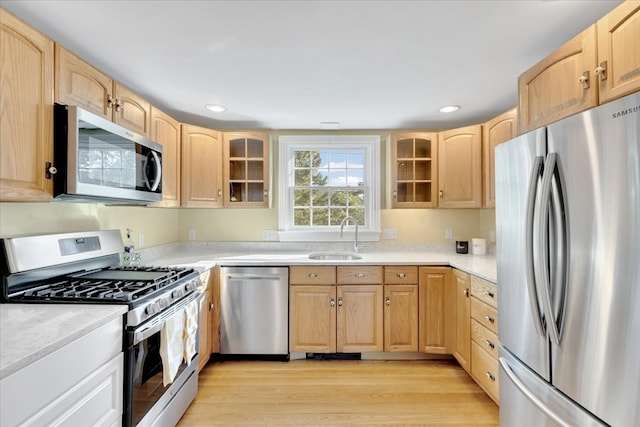 kitchen with light brown cabinetry, sink, appliances with stainless steel finishes, and light hardwood / wood-style flooring