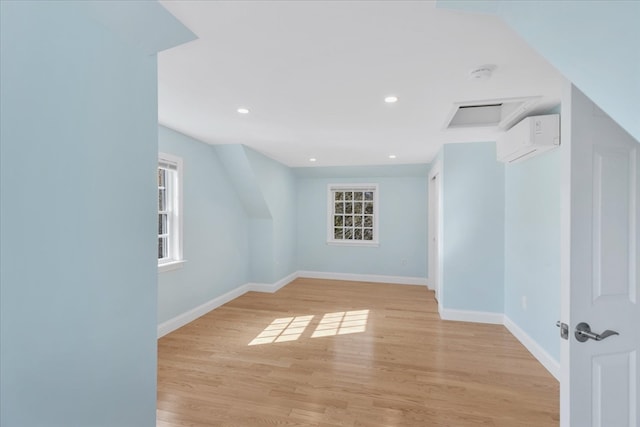 unfurnished room featuring light hardwood / wood-style floors and a wall mounted air conditioner