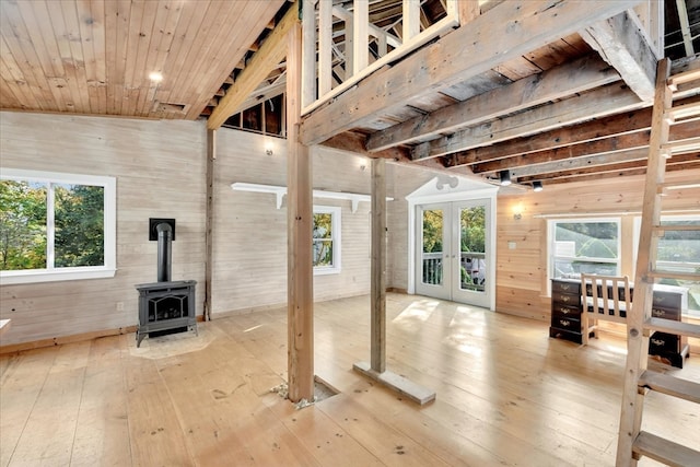 interior space with wood-type flooring, a wood stove, lofted ceiling, and plenty of natural light