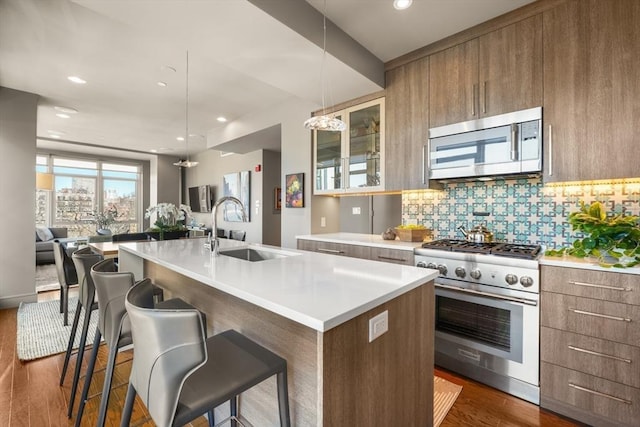 kitchen with appliances with stainless steel finishes, modern cabinets, dark wood-type flooring, and a sink