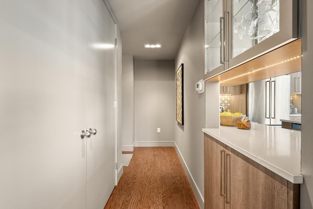 hallway with wood finished floors and baseboards