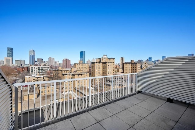 view of patio with a balcony and a city view