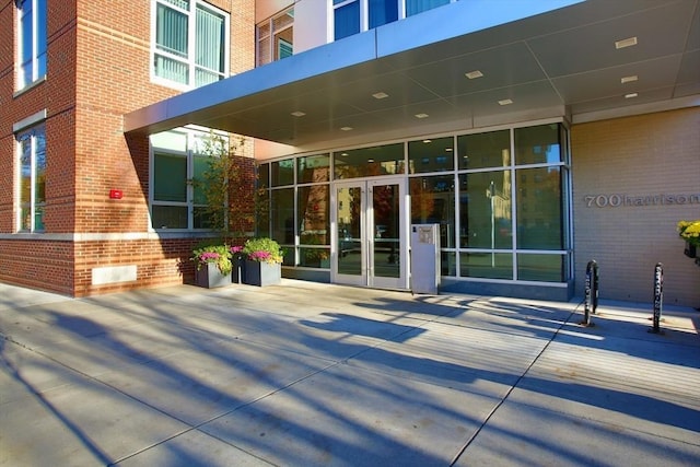 view of exterior entry with french doors and brick siding