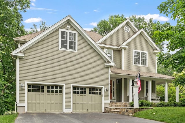 10 Londonderry Ln, Georgetown, MA 01833 - traditional-style house featuring asphalt driveway, covered porch, an attached garage, and roof with shingles