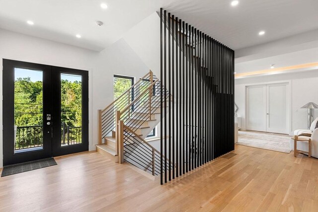 interior space with recessed lighting, french doors, stairway, and light wood finished floors