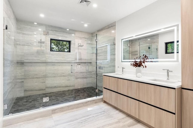 bathroom featuring visible vents, a sink, a shower stall, and double vanity