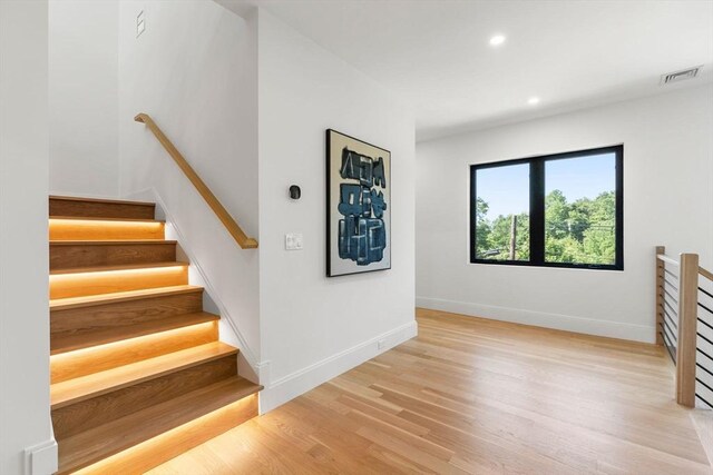 staircase with visible vents, baseboards, wood finished floors, and recessed lighting