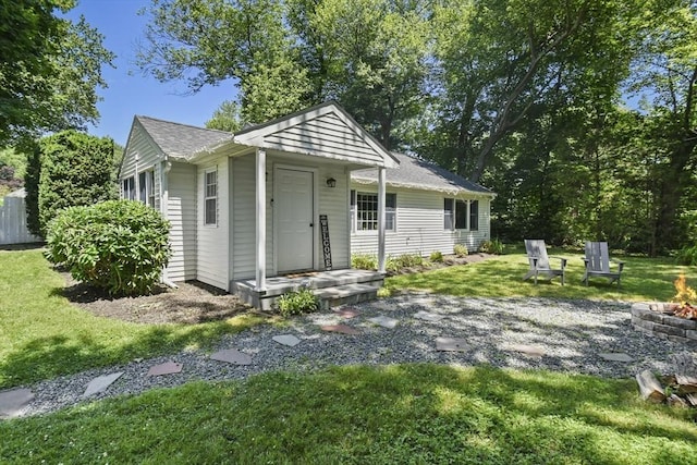 369 Vernon St, Wakefield, MA 01880 - rear view of property featuring a fire pit, a lawn, and roof with shingles