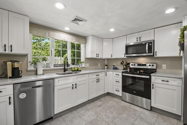 369 Vernon St, Wakefield, MA 01880 - kitchen featuring stainless steel appliances, light countertops, white cabinetry, recessed lighting, and light tile patterned floors