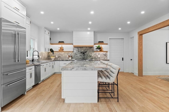 1 Maud Graham Cir, Burlington, MA 01803 - kitchen with stainless steel appliances, open shelves, a kitchen island, white cabinets, and premium range hood