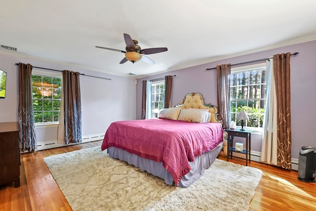 bedroom featuring ceiling fan, crown molding, wood-type flooring, and a baseboard radiator