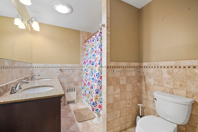 bathroom with radiator heating unit, toilet, walk in shower, tile walls, and vanity