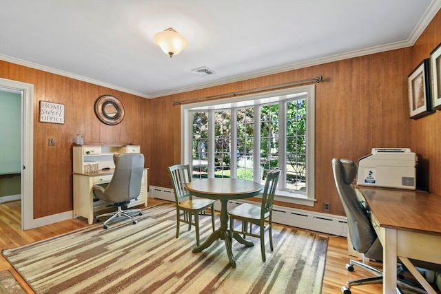 office area with ornamental molding, wooden walls, and light hardwood / wood-style floors