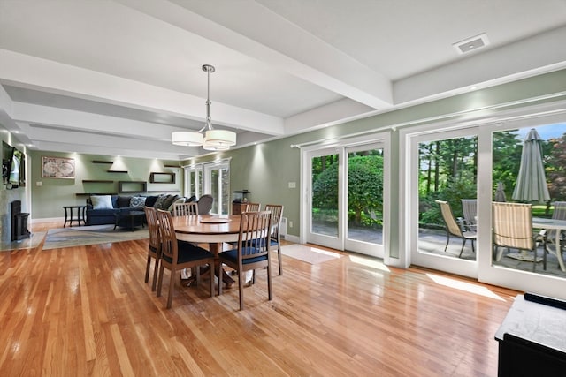 dining space featuring beam ceiling and light wood-type flooring