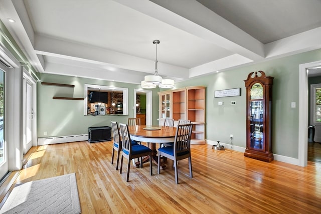 dining area featuring baseboard heating, light hardwood / wood-style flooring, and a healthy amount of sunlight