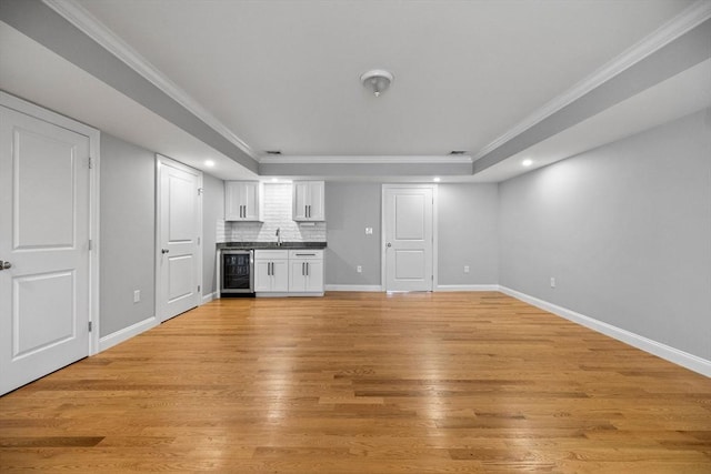 125 Ash St Unit 1, Waltham, MA 02453 - unfurnished living room with beverage cooler, a tray ceiling, recessed lighting, light wood finished floors, and crown molding