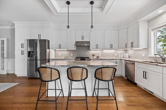 125 Ash St Unit 1, Waltham, MA 02453 - kitchen with appliances with stainless steel finishes, a center island, a kitchen bar, crown molding, and white cabinets