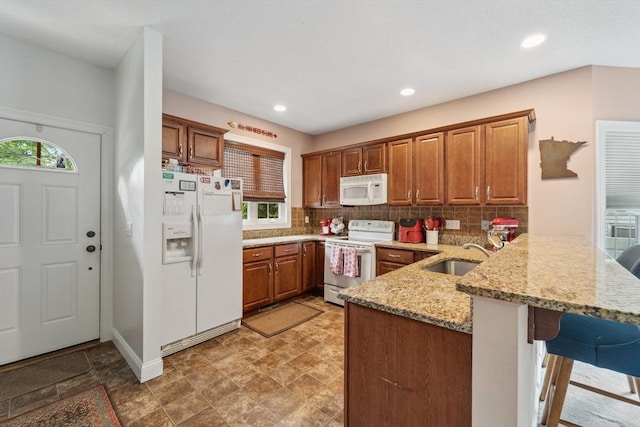 49 Camden St Unit 49, South Hadley, MA 01075 - kitchen featuring white appliances, a sink, a peninsula, brown cabinetry, and backsplash